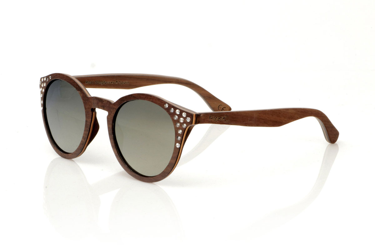 Wood eyewear of Walnut LANA. LANA wooden sunglasses, from our collection of organic glasses, entirely made of laminated walnut wood. This model perfectly combines natural elegance with an iconic design: a rounded shape with a straight eyebrow, creating a visual balance that enhances any type of face. But what really sets LANA apart are the sparkling Czech crystals embedded at the ends of the brows, adding a touch of light and sophistication. Ideal for those looking to stand out with a unique accessory, LANA is not just a pair of glasses, but a statement of style and ecological awareness. Measurements 147x50mm Caliber 47 for Wholesale & Retail | Root Sunglasses® 